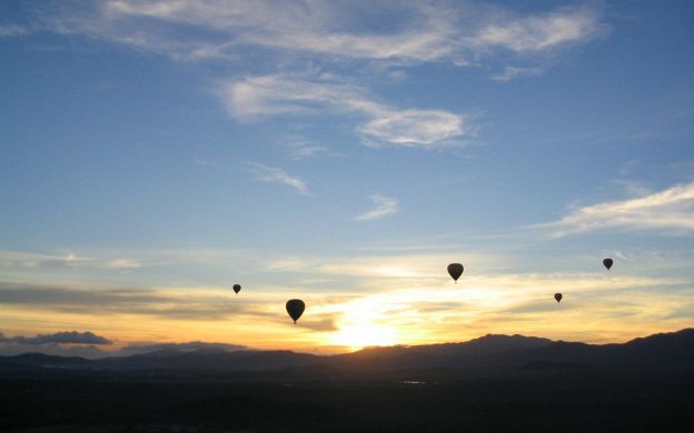 A fleet of colorful hot air balloons ascend into the painted canvas of the twilight sky, adding magic to Melbourne's skyline.